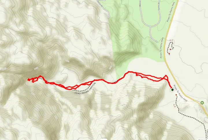 The image shows a topographic map with a marked trail route in red, indicating elevation changes around Dead Indian Canyon.