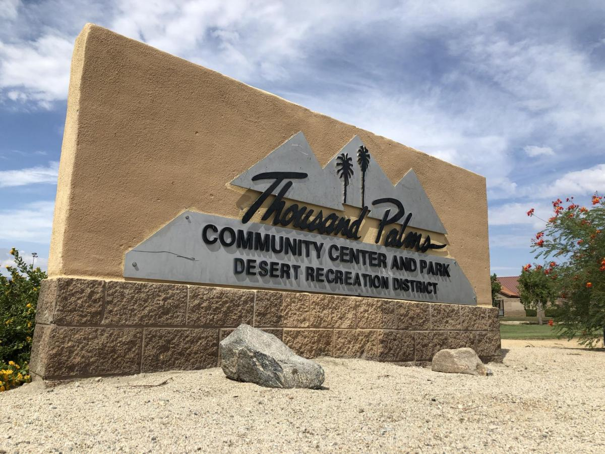 Sign for Thousand Palms Community Center and Park, part of the Desert Recreation District, in a desert landscape.