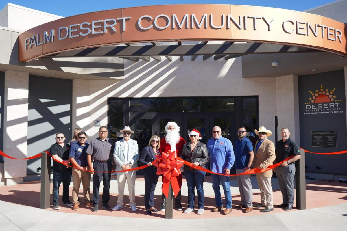 A group of people, including someone in a Santa costume, are celebrating the ribbon-cutting ceremony for the Palm Desert Community Center.