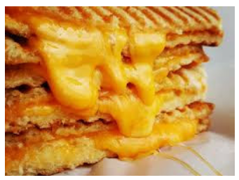 A stack of grilled cheese sandwiches with melting cheese.