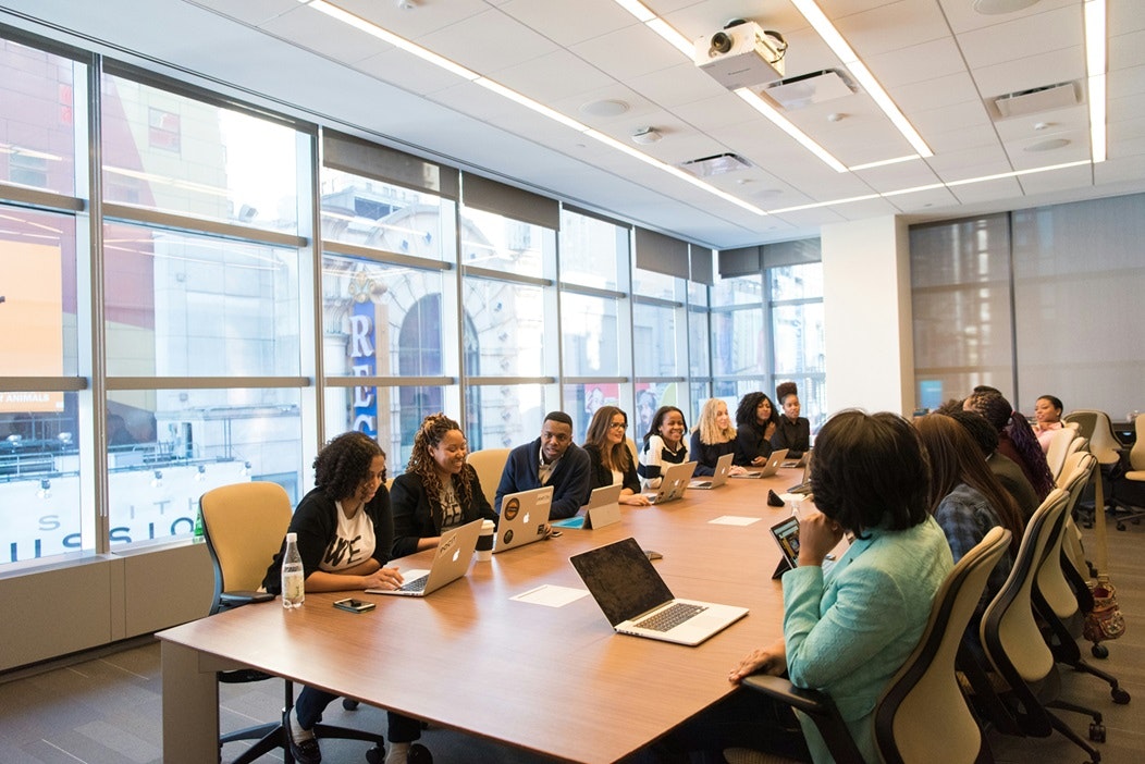 A diverse group of people in a modern meeting room, engaged in a discussion.