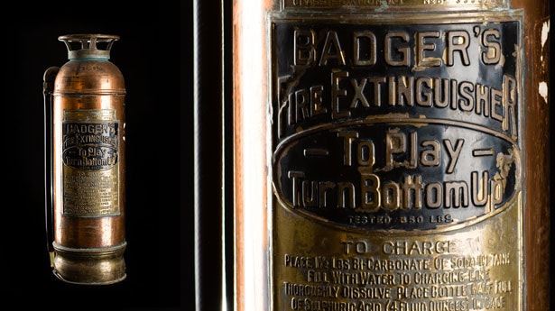 An antique fire extinguisher branded "Badger's" with instructions for use and charging, showcasing vintage design and craftsmanship.