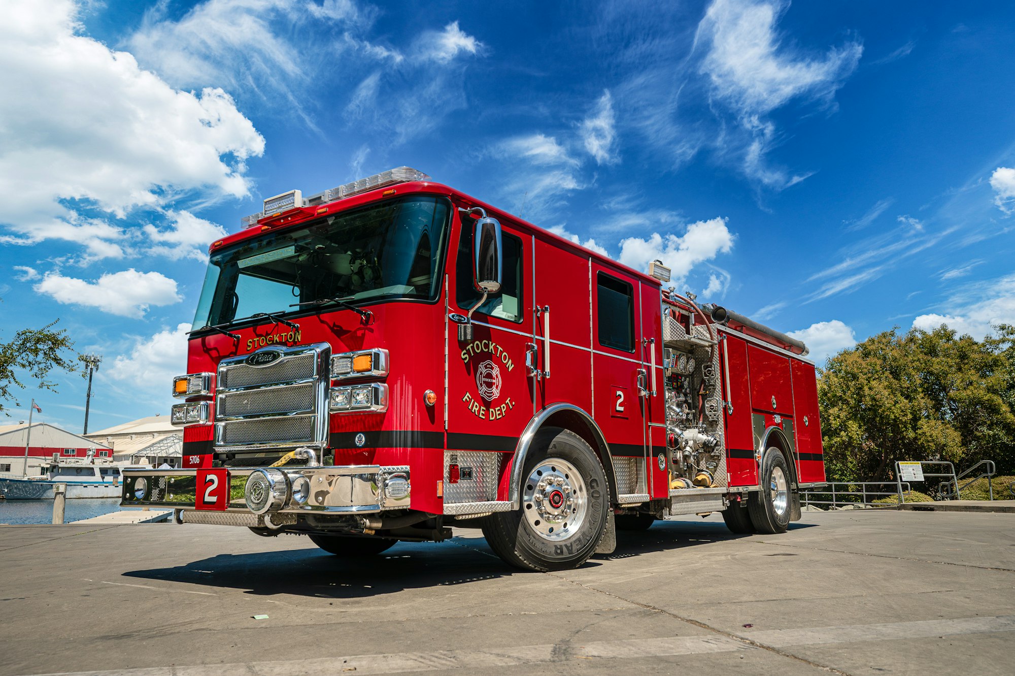 Red fire truck parked outside, clear blue sky.