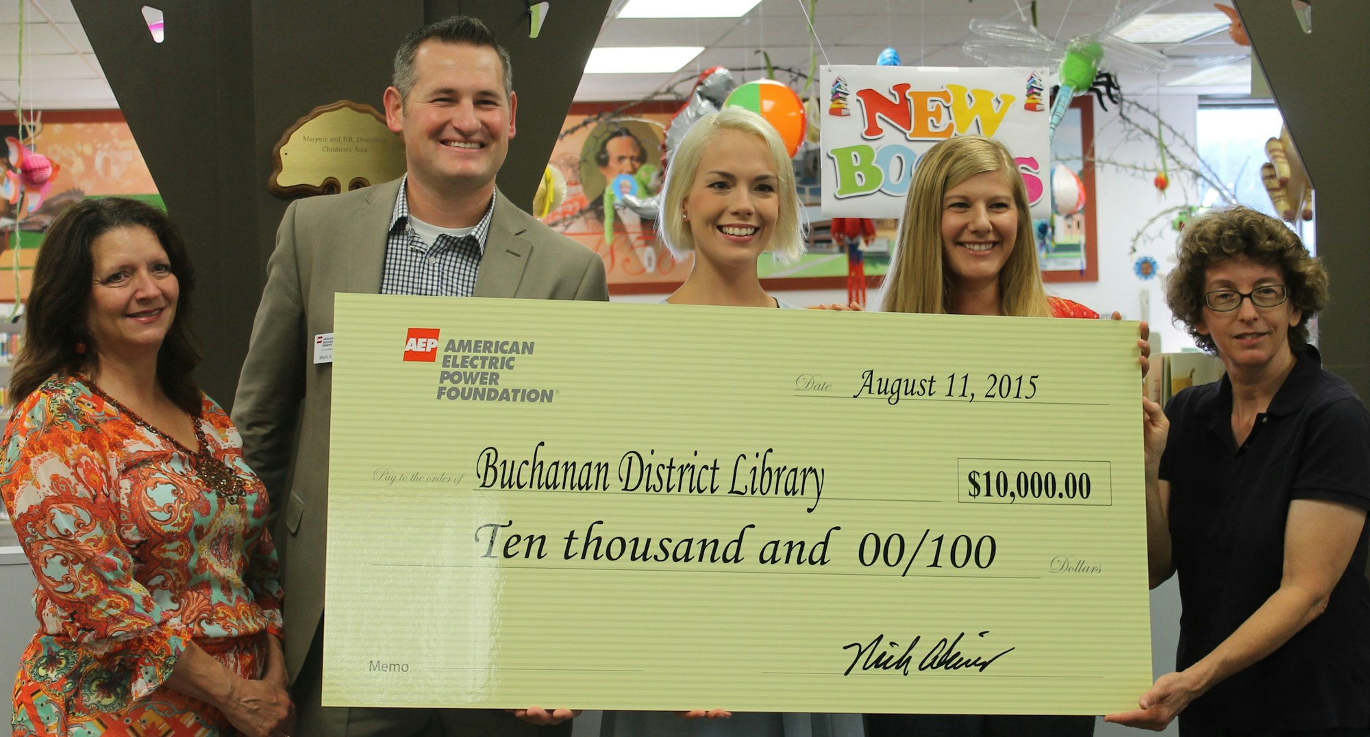 People holding a giant check for $10,000 from American Electric Power Foundation to Buchanan District Library.