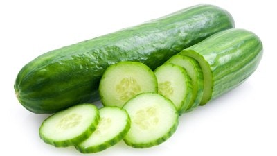 Whole and sliced cucumbers on a white background.