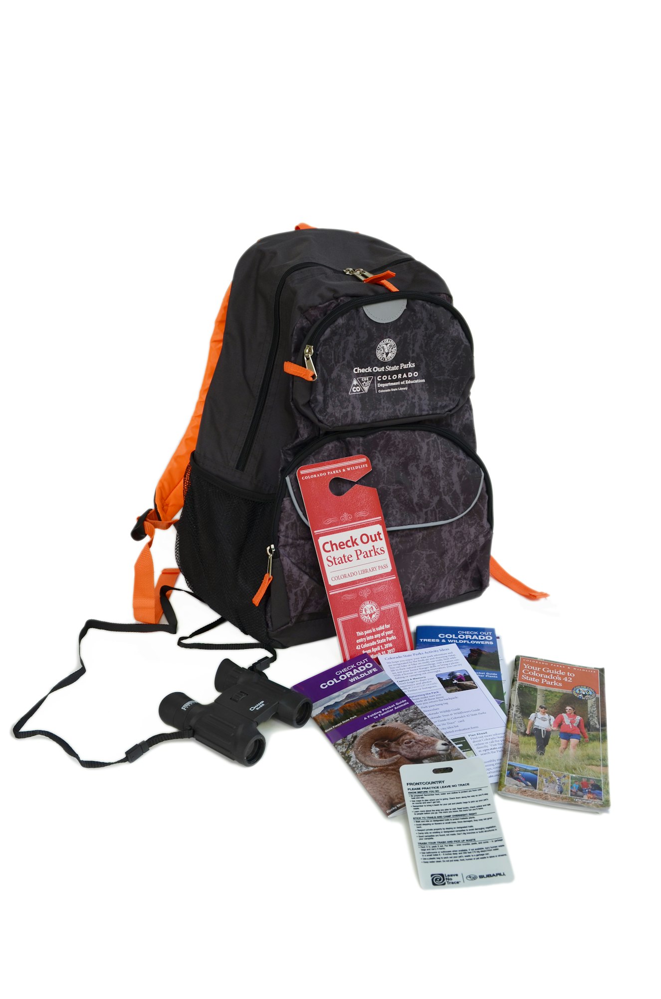 A backpack, binoculars, pamphlets related to Colorado State Parks, and some informational cards.