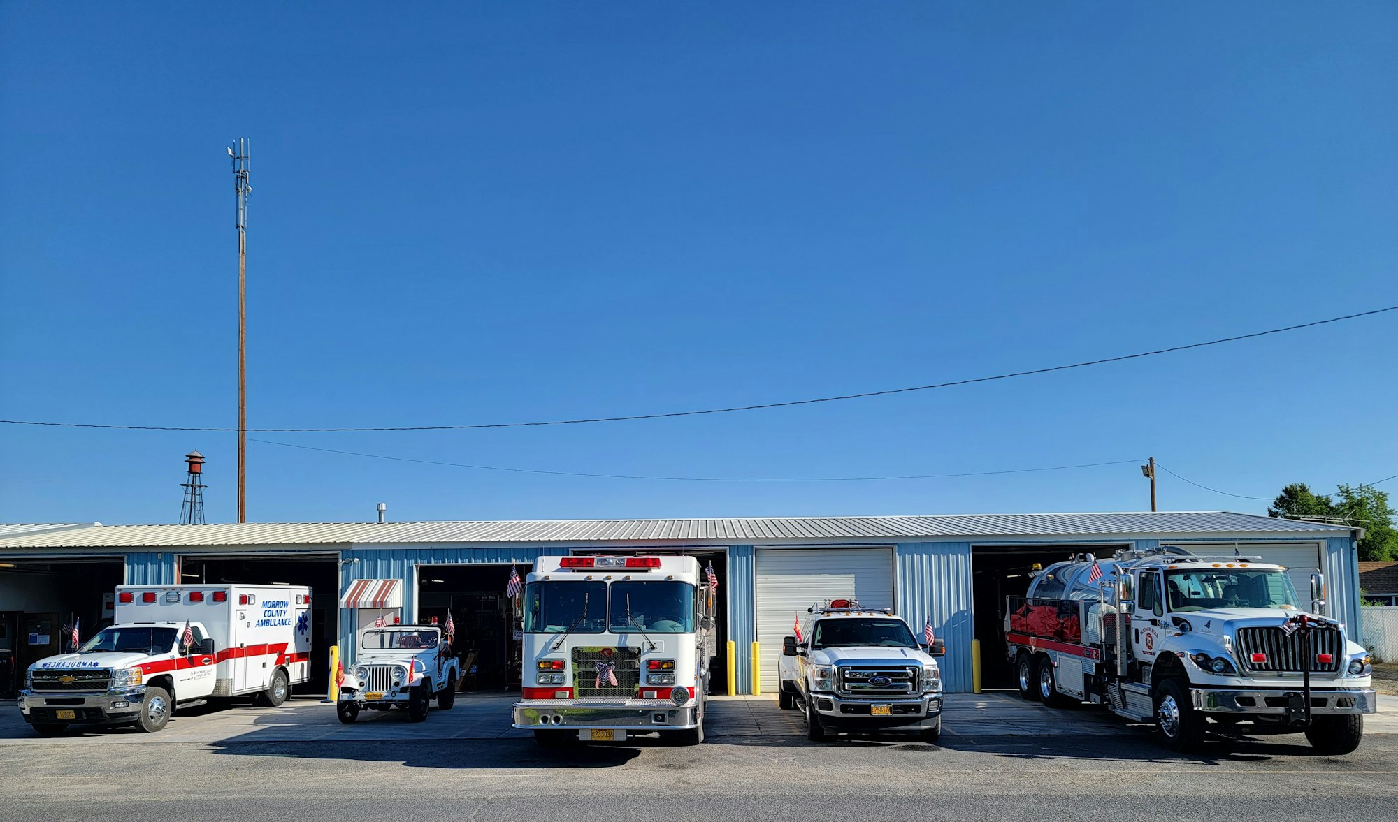 May contain: pickup truck, transportation, truck, vehicle, fire station, fire truck, car, and flag