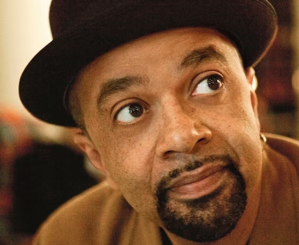 A person wearing a brown hat gazes to the side.
