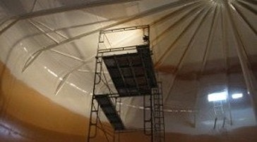 A metal scaffold inside a room with a tent-like ceiling.
