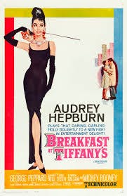 A vintage movie poster for "Breakfast at Tiffany's," featuring Audrey Hepburn in a stylish black dress. Colorful design elements included.