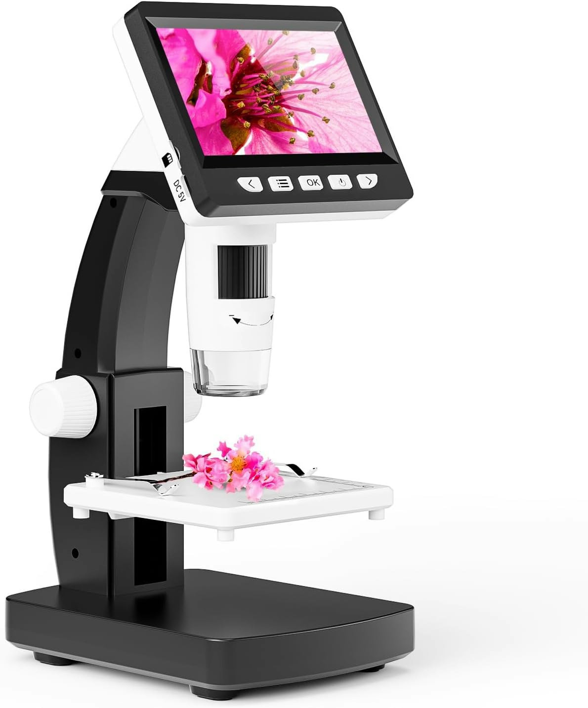 A digital microscope displaying a magnified pink flower on its screen, with a flower sample on the stage below the lens.