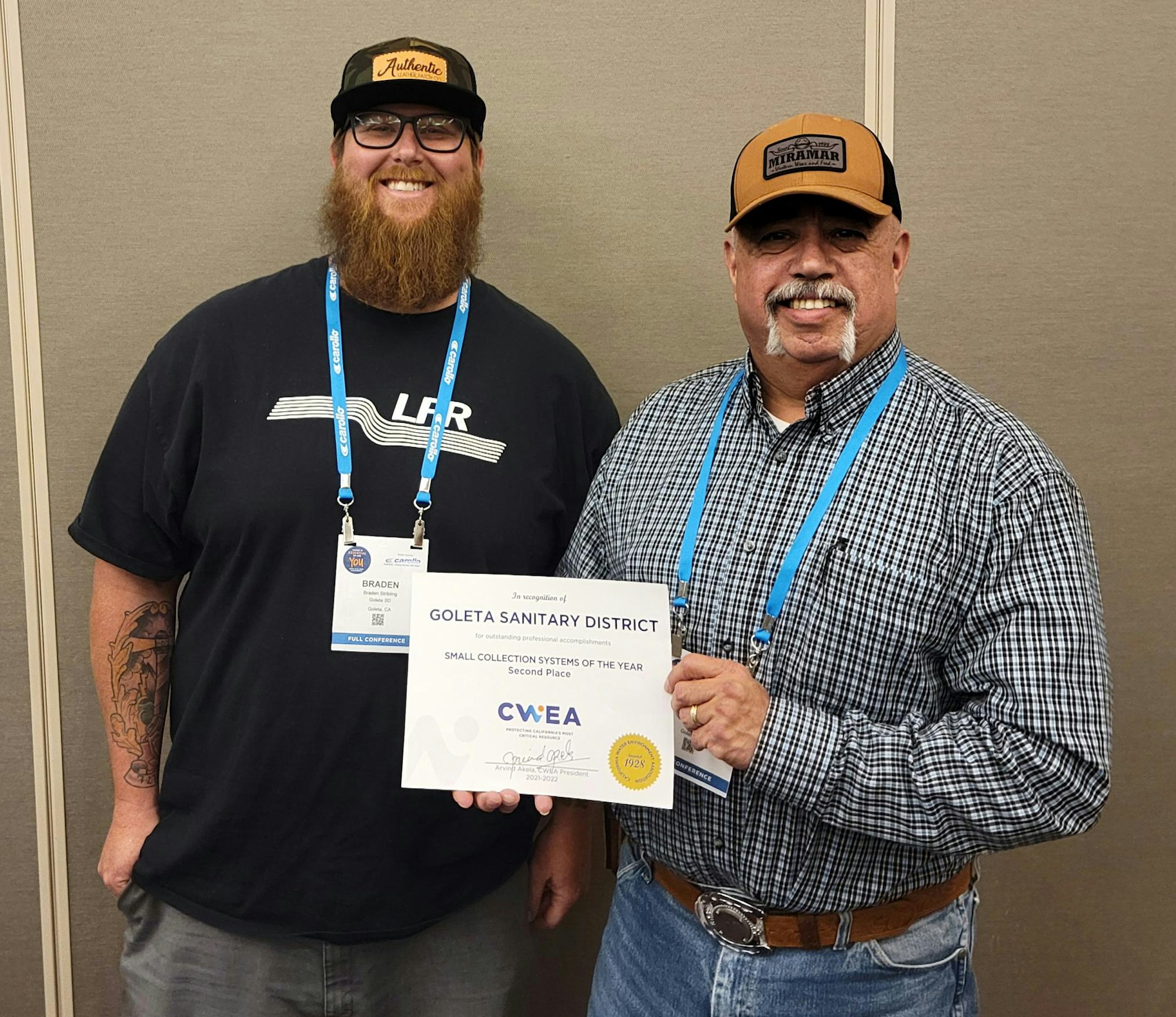 Two men pose together, holding an award for the Goleta Sanitary District's second place in small collection systems of the year.