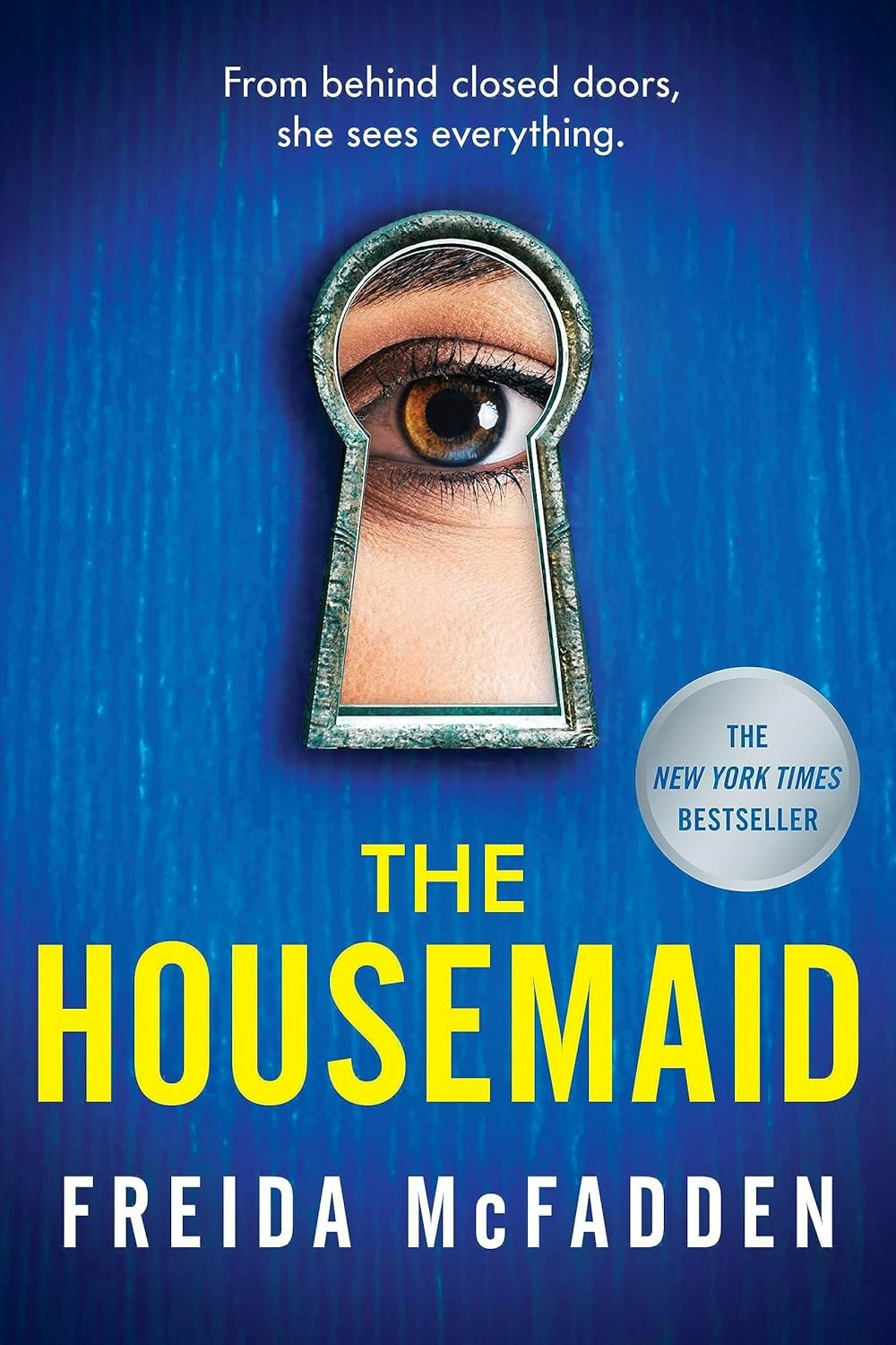 Book cover of "The Housemaid" by Freida McFadden featuring an eye in a keyhole.
