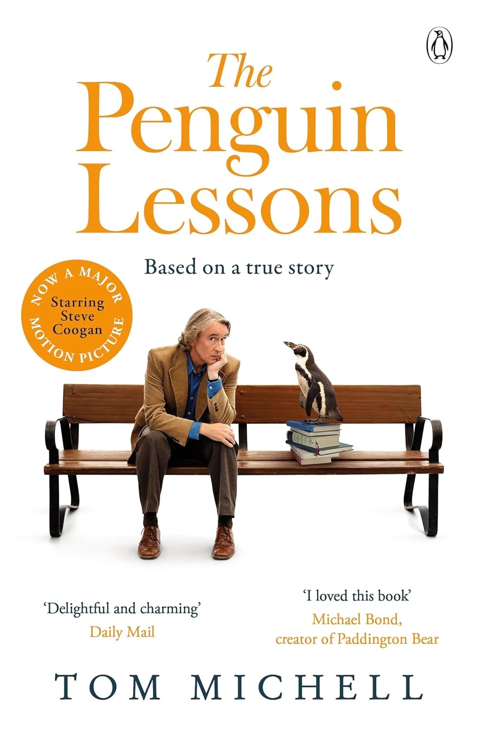 Book cover: "The Penguin Lessons" by Tom Michell. Man and penguin on a bench, based on a true story, includes movie adaptation.