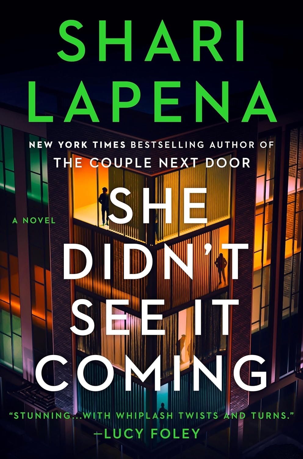 Book cover: "She Didn't See It Coming" by Shari Lapena, featuring silhouettes in a colorful, windowed structure.