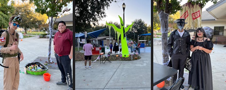 People in Halloween costumes at an outdoor event with decorations and stands.