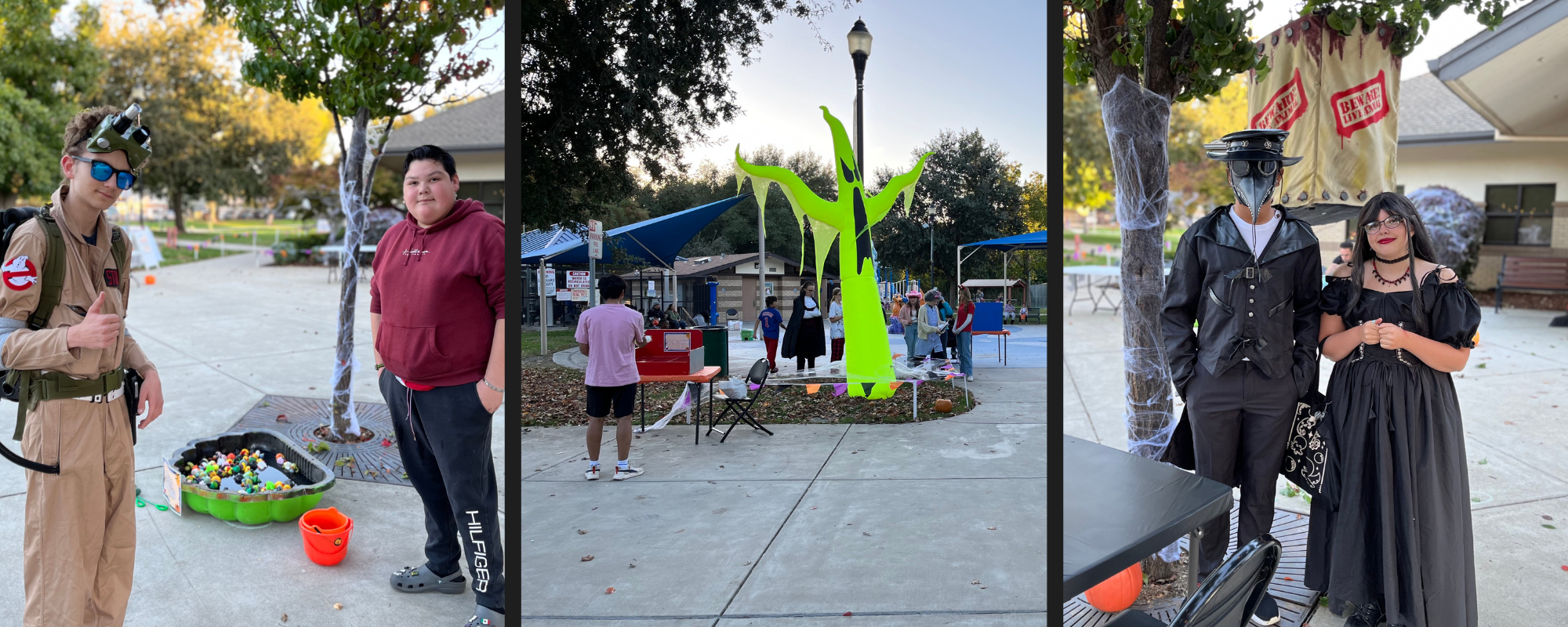 People in Halloween costumes at an outdoor event with decorations and stands.