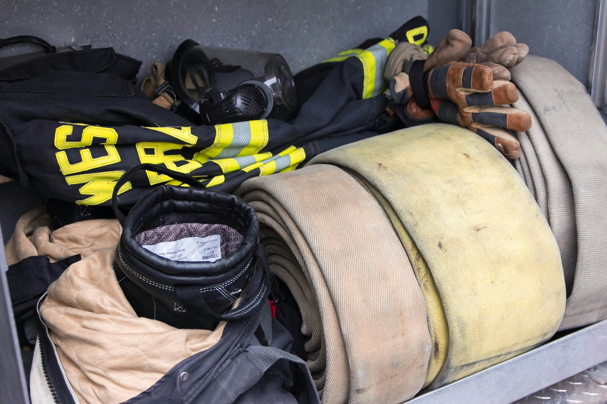 Firefighter gear: hose, helmet, gloves, jacket, mask.
