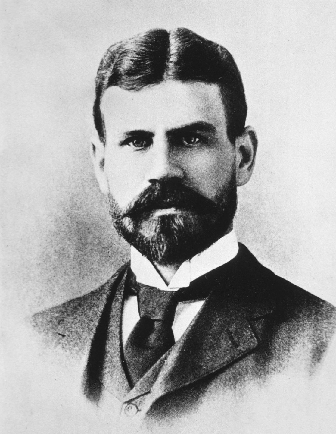 A vintage portrait of a man with a beard and mustache, wearing a suit and tie.
