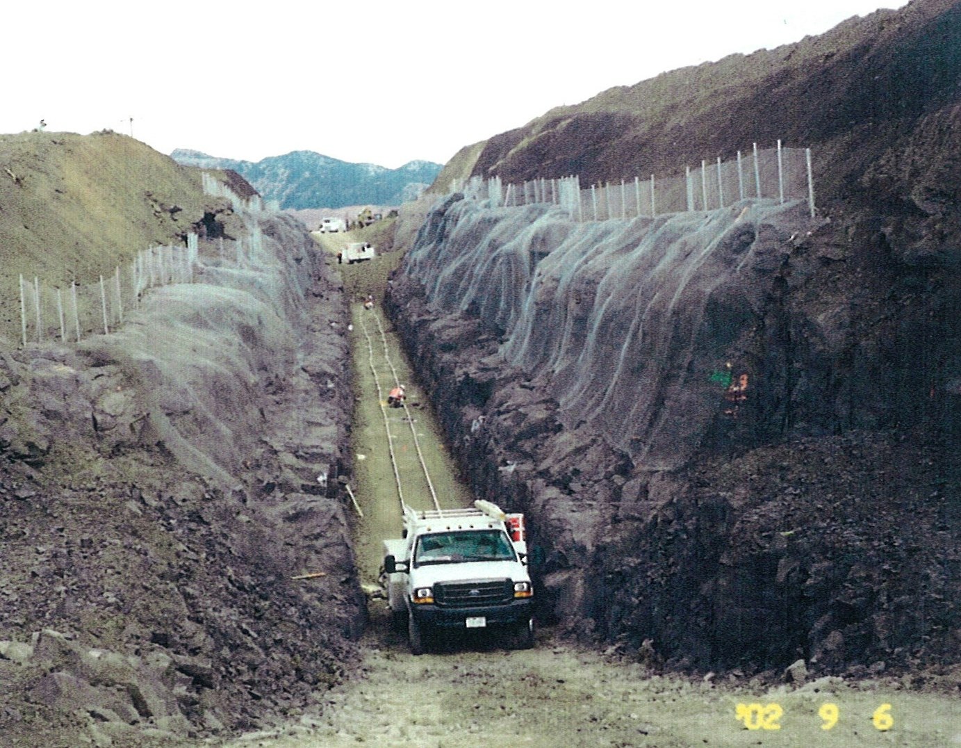 A truck on a road with unusual, draped lava-like formations on either side.
