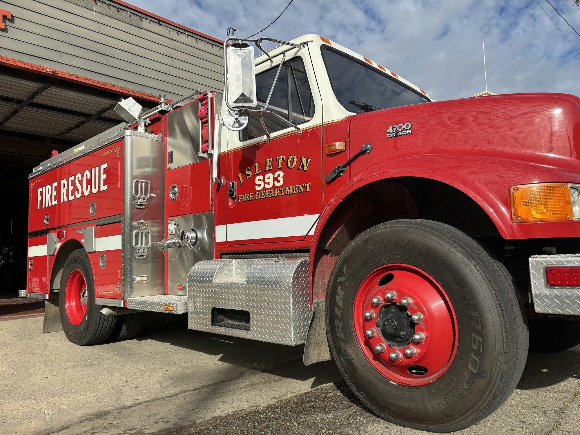 A red fire rescue truck parked outside a building with "Isleton Fire Department 593" on the side.