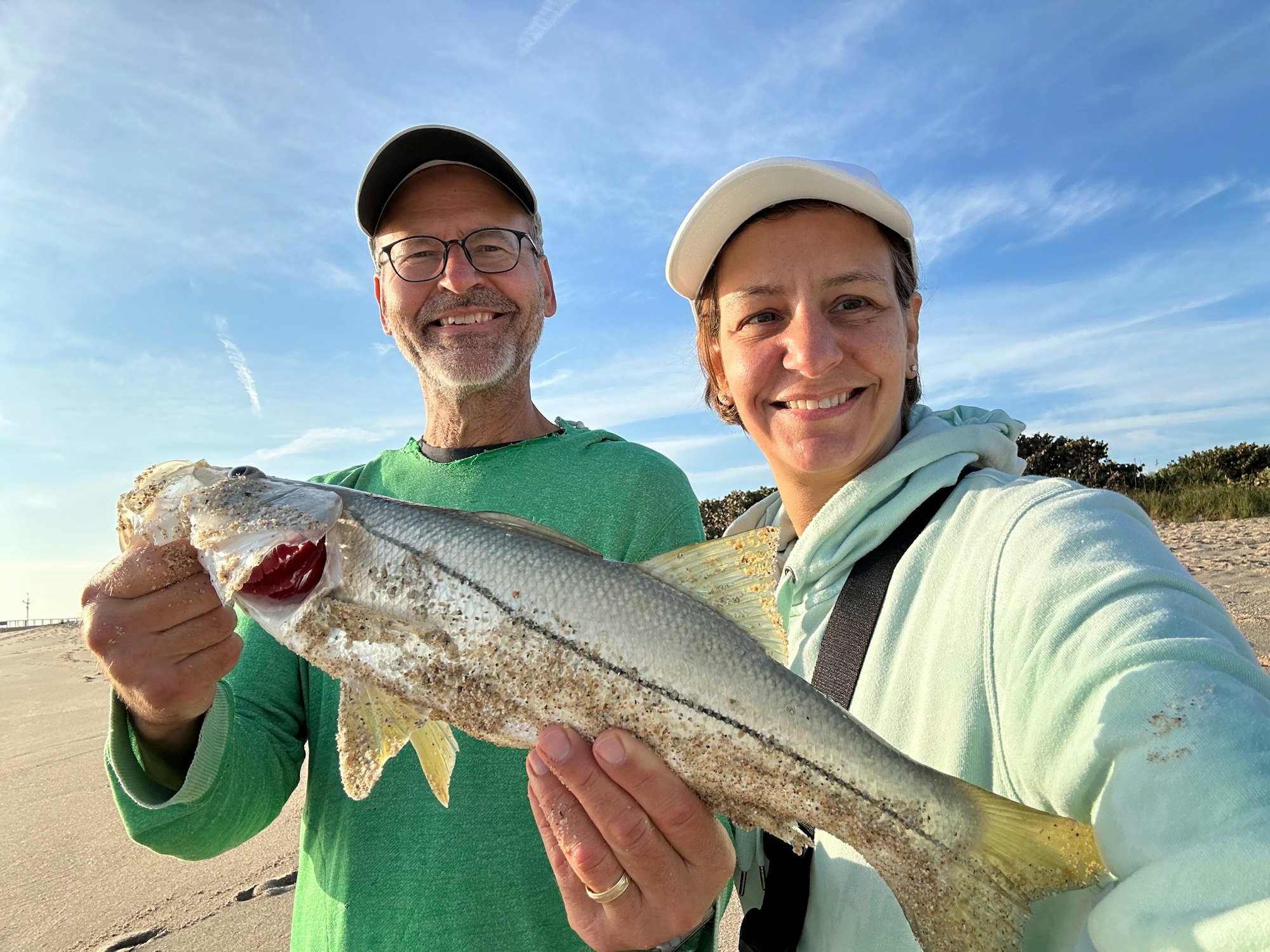 May contain: face, head, person, photography, portrait, baseball cap, cap, clothing, hat, animal, fish, sea life, accessories, glasses, trout, adult, male, man, jewelry, ring, female, and woman