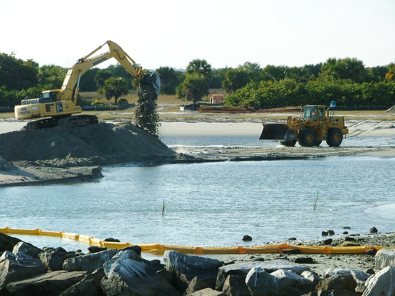 heavy equipment moving sand from tide pool