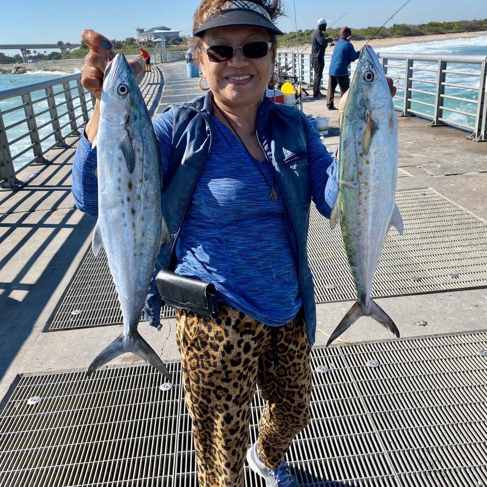 woman holding two spanish mackerel on the north jetty