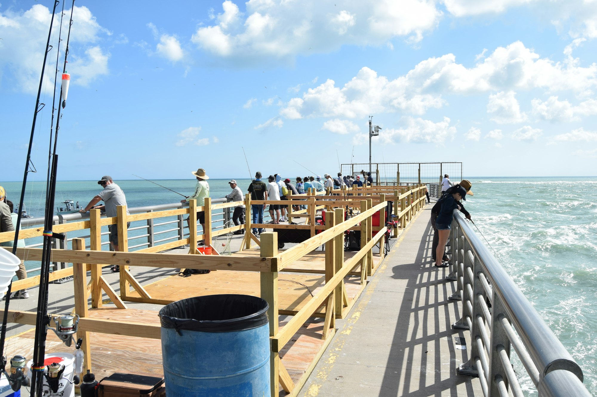 May contain: water, waterfront, handrail, fishing, leisure activities, outdoors, clothing, hat, person, pier, railing, and port