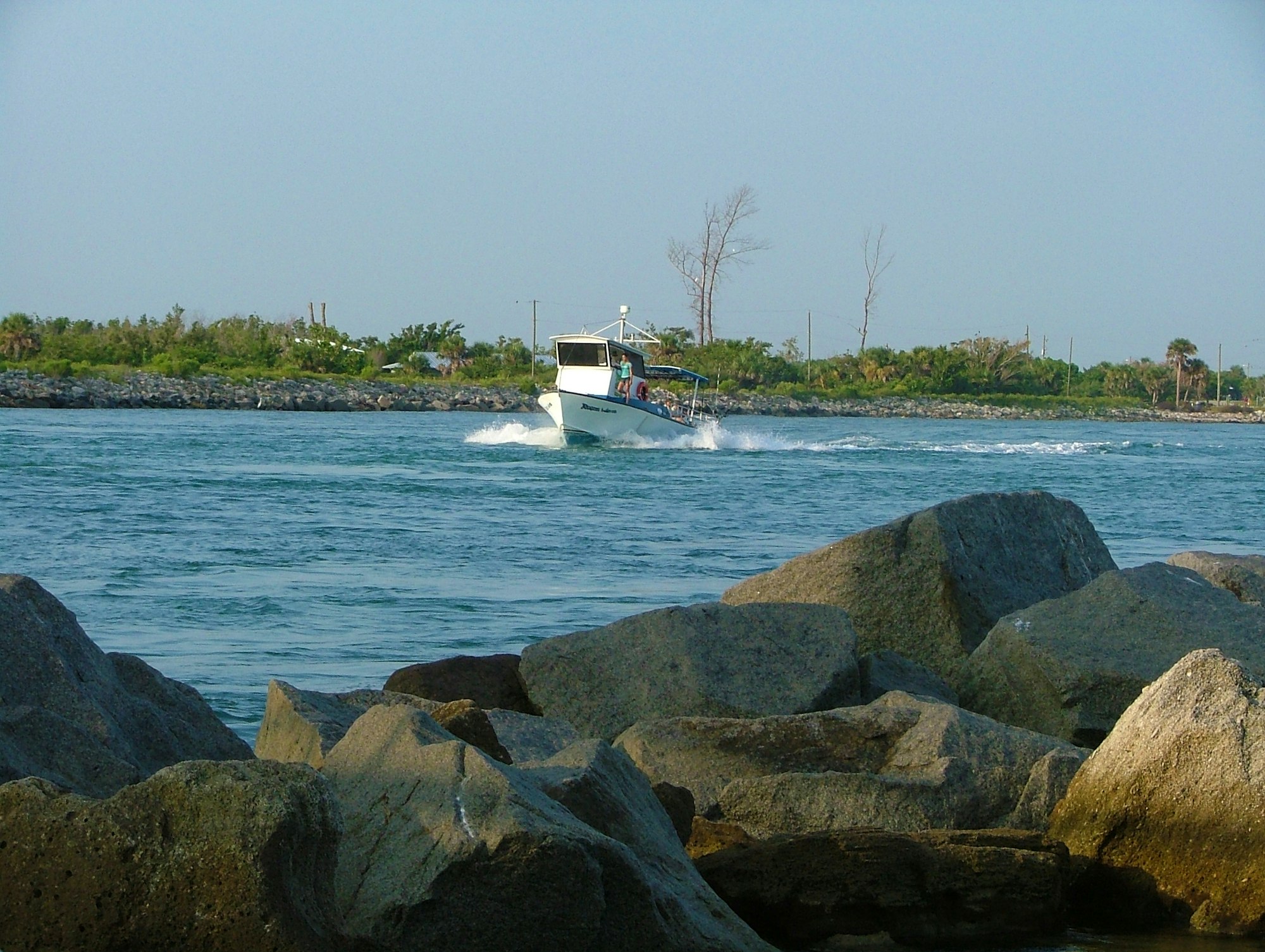 boat with large armor stone rocks in foreground