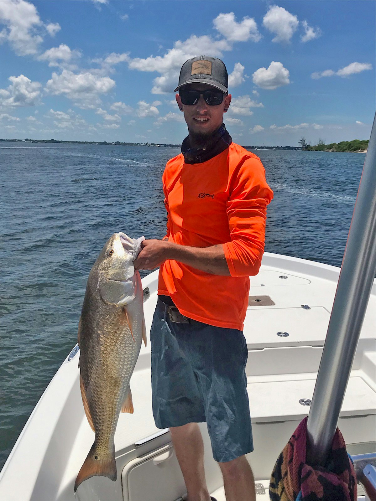 man on boat holding large redfish