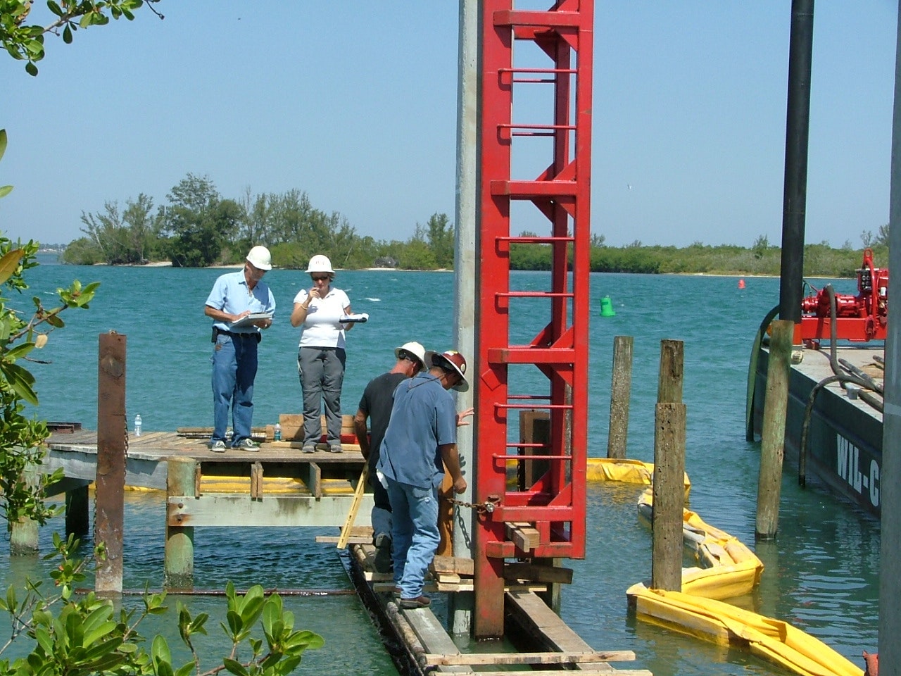 pile driving equipment with engineers and construction crew overseeing the work