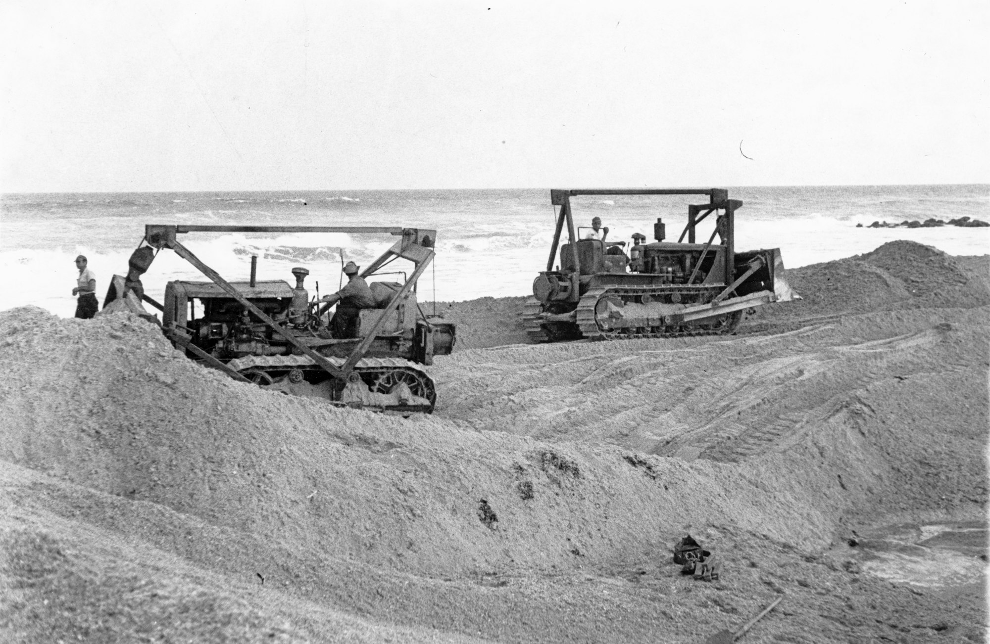 Two bulldozers moving sand from 1948