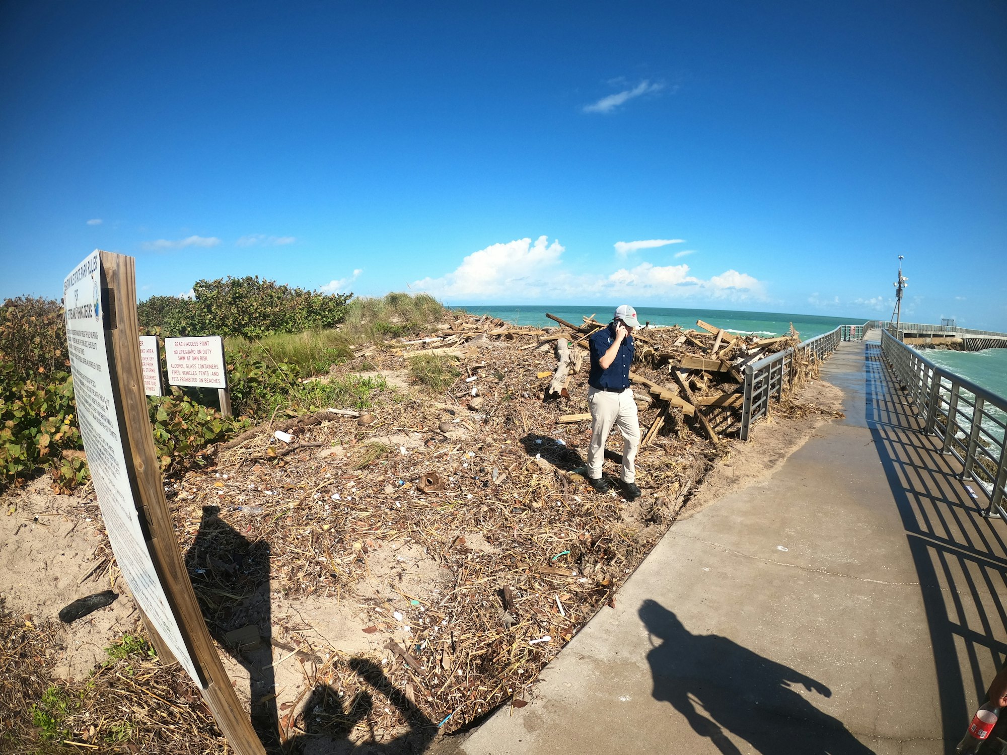 May contain: wood, path, handrail, walkway, water, waterfront, person, soil, photography, clothing, footwear, shoe, outdoors, nature, and hat