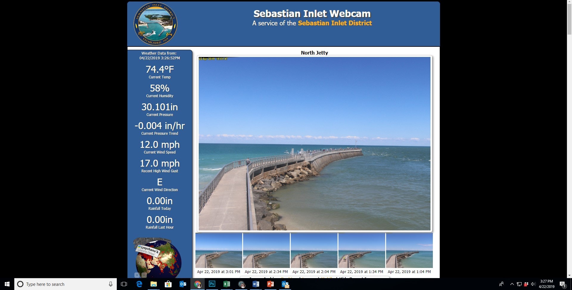 A view from Sebastian Inlet Webcam showing a jetty, sea, blue sky. Weather data: 74.4°F, 58% humidity, 12 mph wind.