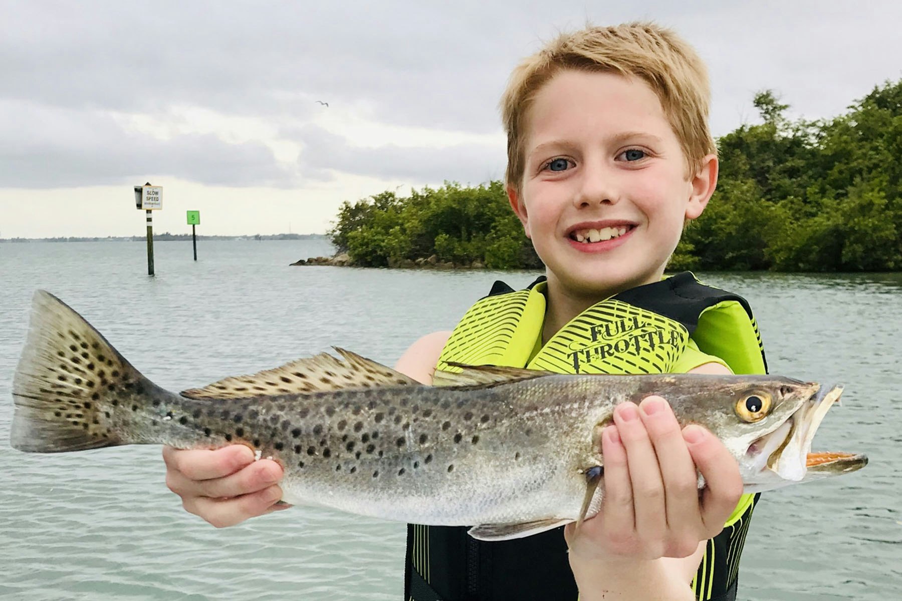 Young boy holding speckled sea trout
