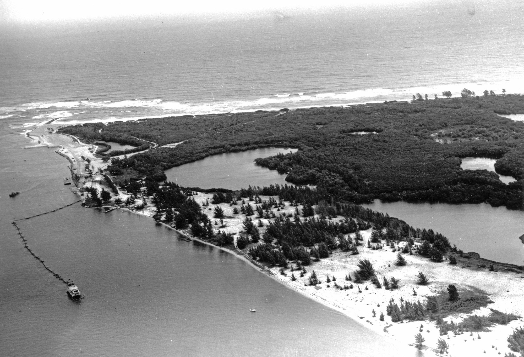 aerial view of the southern shoreline of the inlet with dredge and floating pipe