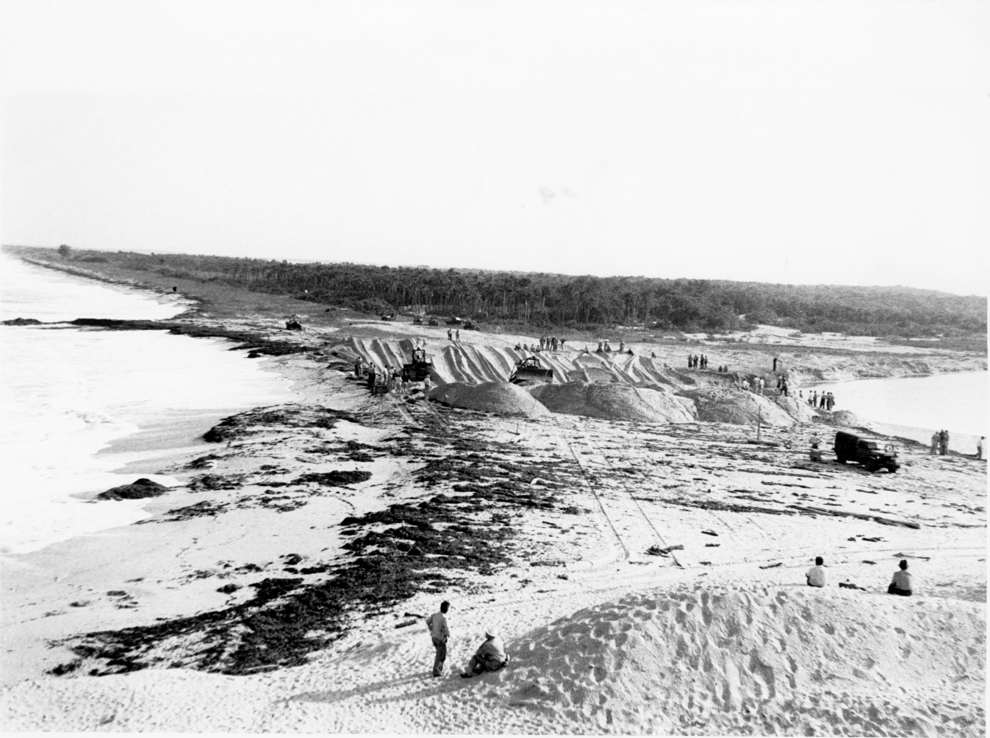 wide view of bulldozers working the final section of sand between the Indian River and the waters of the Atlantic Ocean