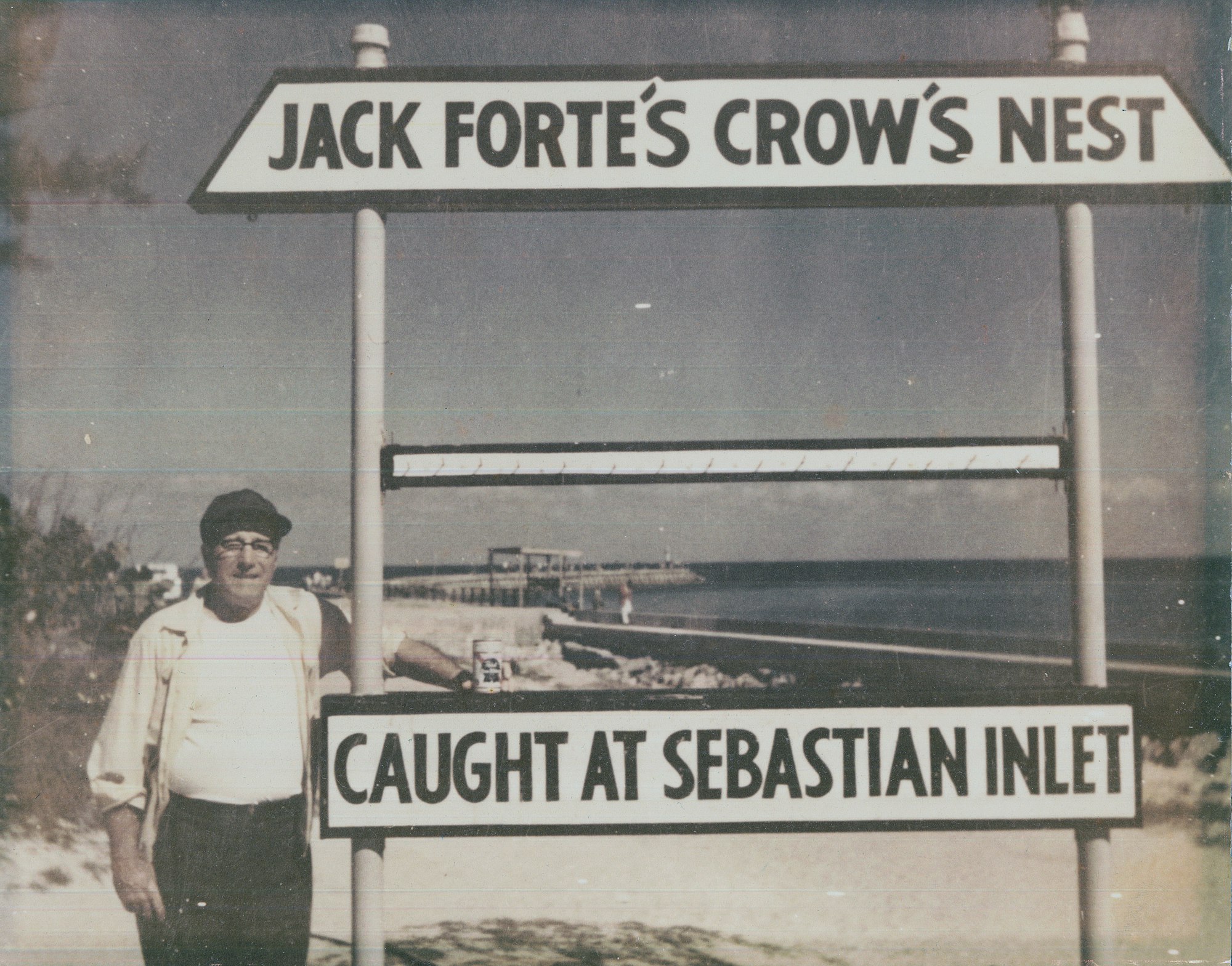 man standing in front of sign reading Jack Forte's Crow's Nest, Caught at Sebastian Inlet