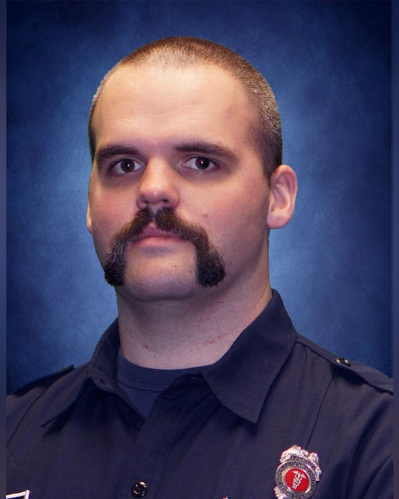 May contain: officer, person, police officer, captain, adult, male, man, head, face, photography, and portrait