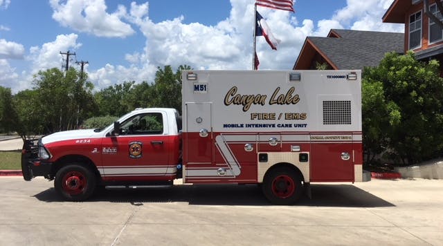 A Canyon Lake Fire/EMS Mobile Intensive Care Unit vehicle is parked outside on a sunny day.
