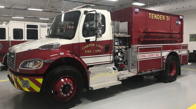 A red fire tender truck labeled "Tender 51" from Canyon Lake Fire/EMS inside a garage.
