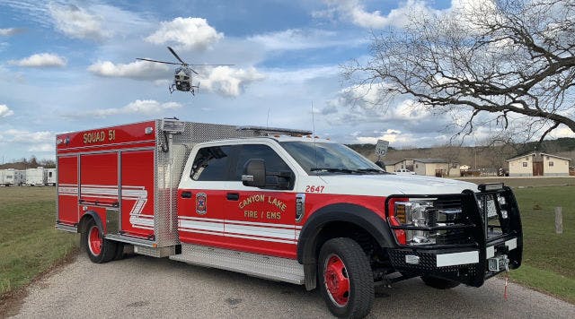 A firetruck with "Squad 51" labeled on it and a helicopter flying in the background.