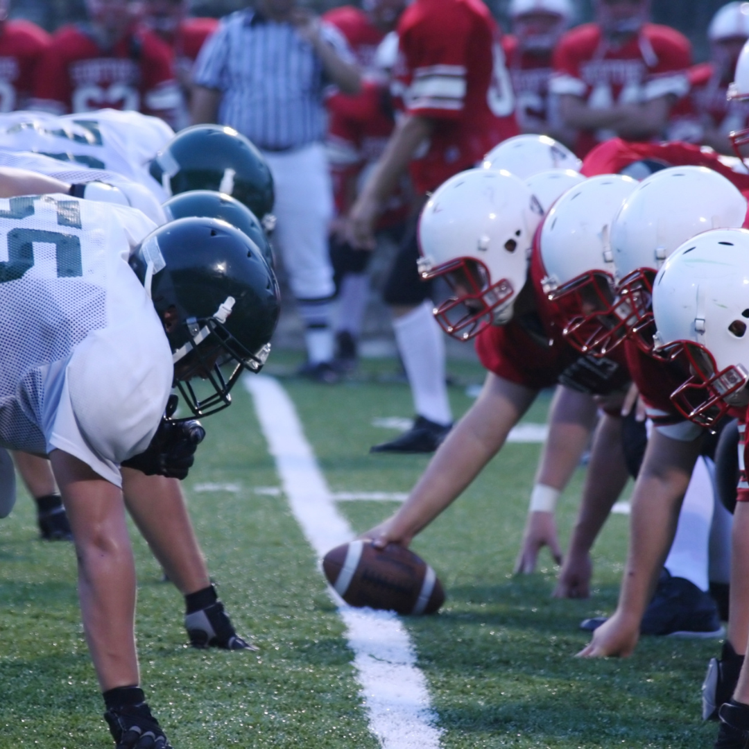 American football players lined up at scrimmage, ready for play.