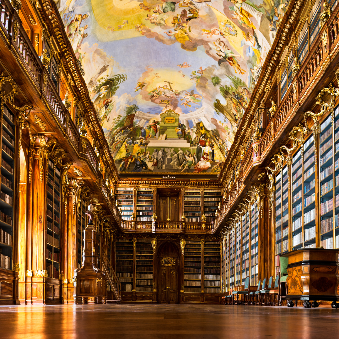 Ornate library with a painted ceiling and rows of bookshelves.