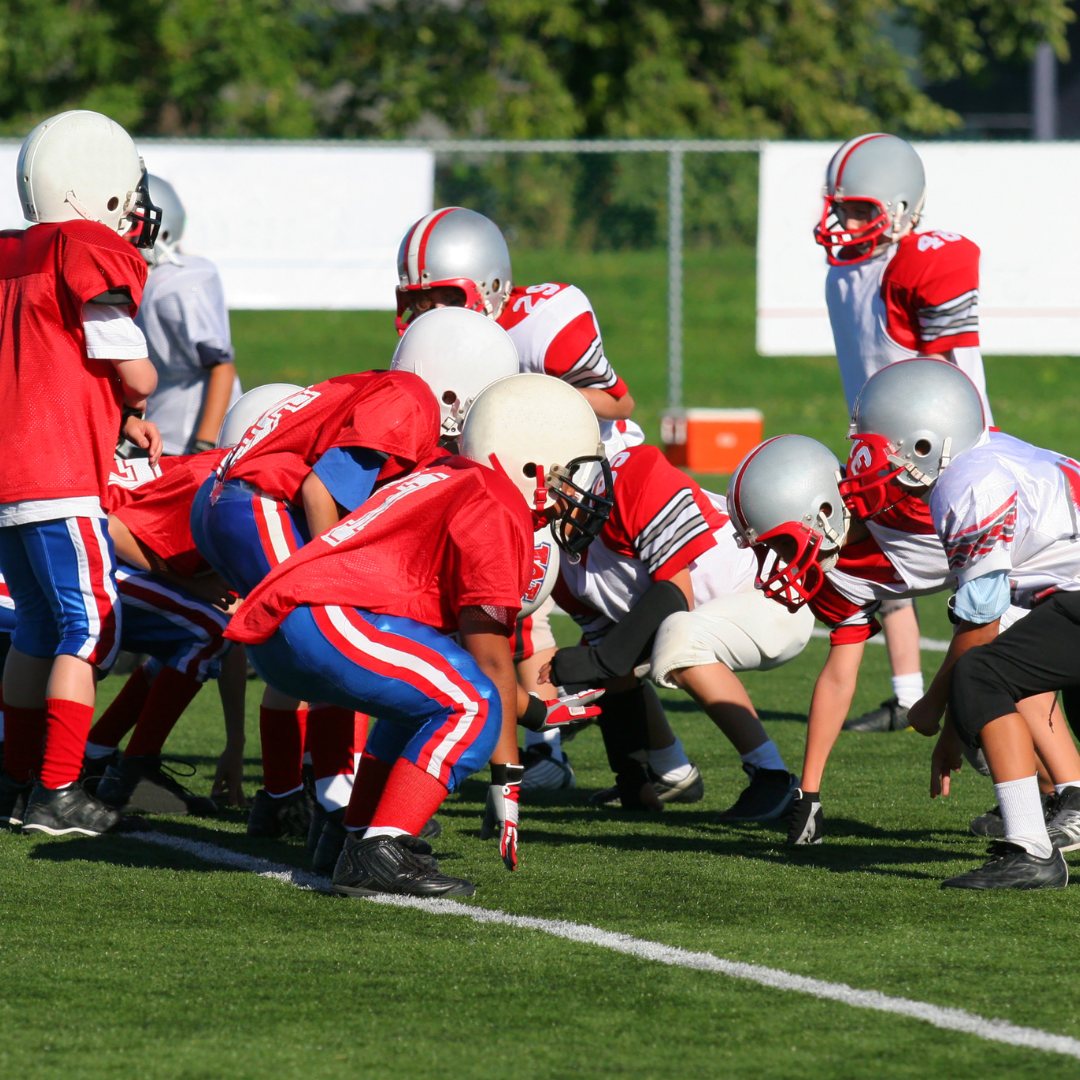 Youth football teams lined up on the field, ready to play.