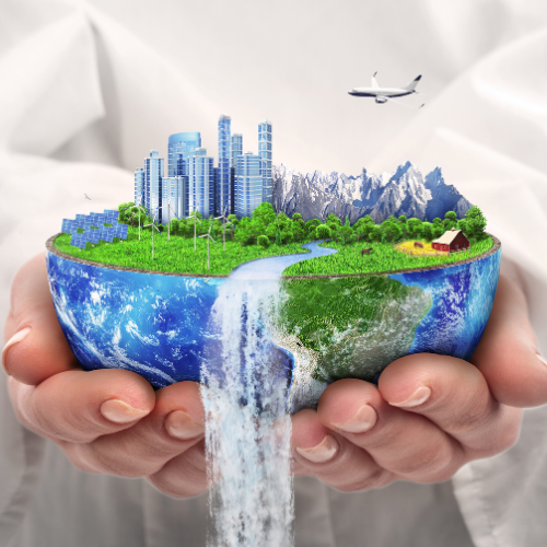 A hand holds a globe with a vibrant, green landscape, modern buildings, mountains, wind turbines, and an airplane above.