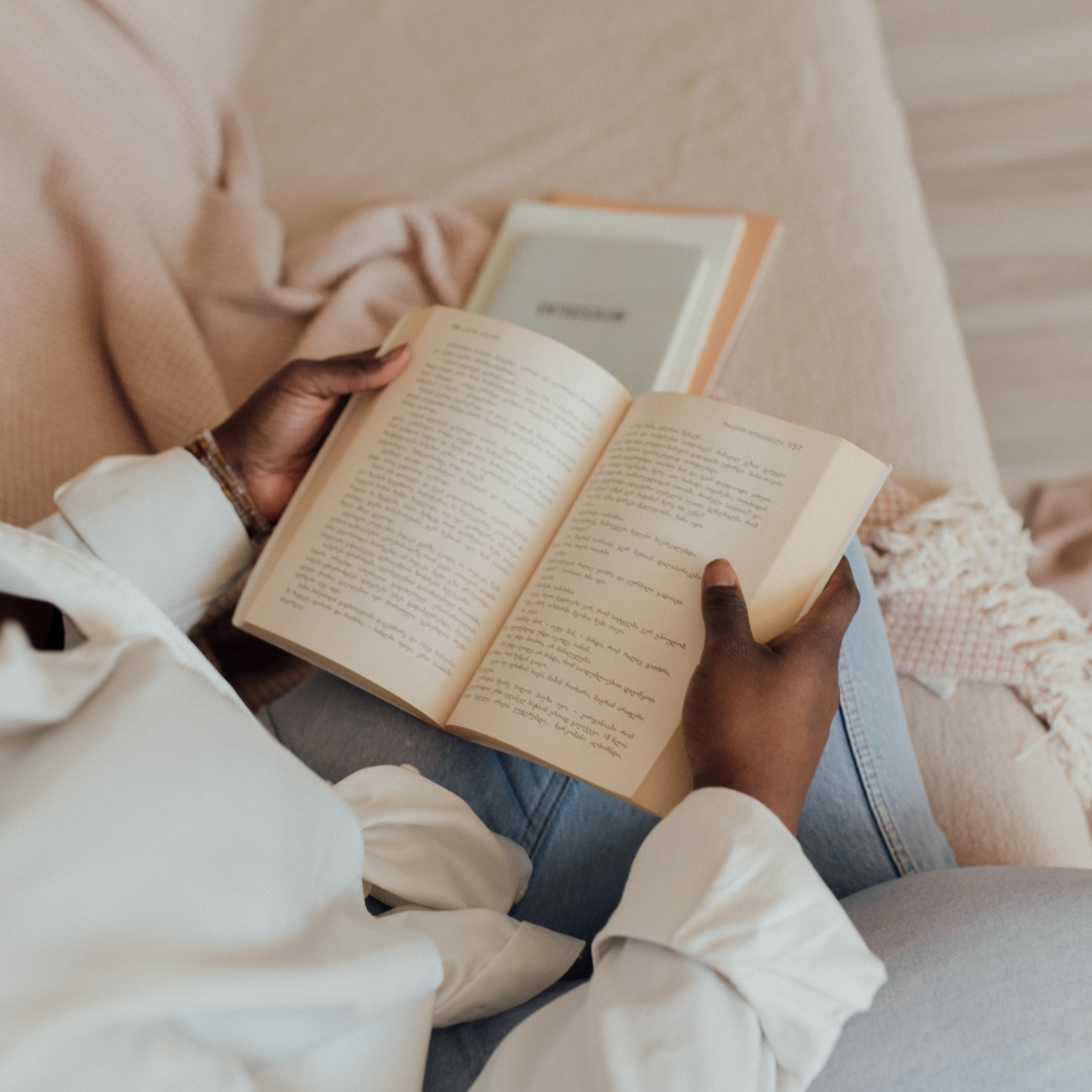 Person reading a book, cozy atmosphere with neutral tones.