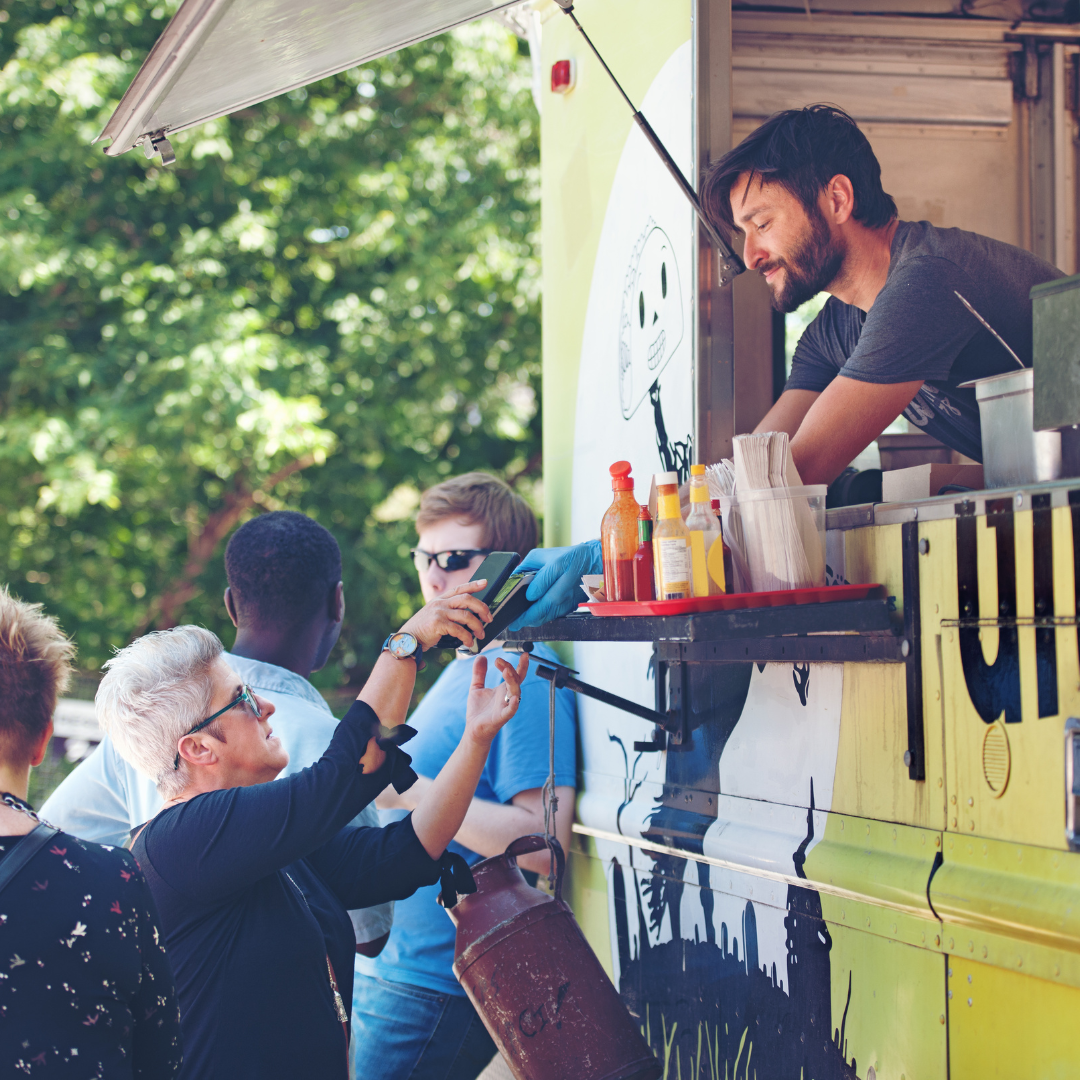People ordering food at a street food truck.