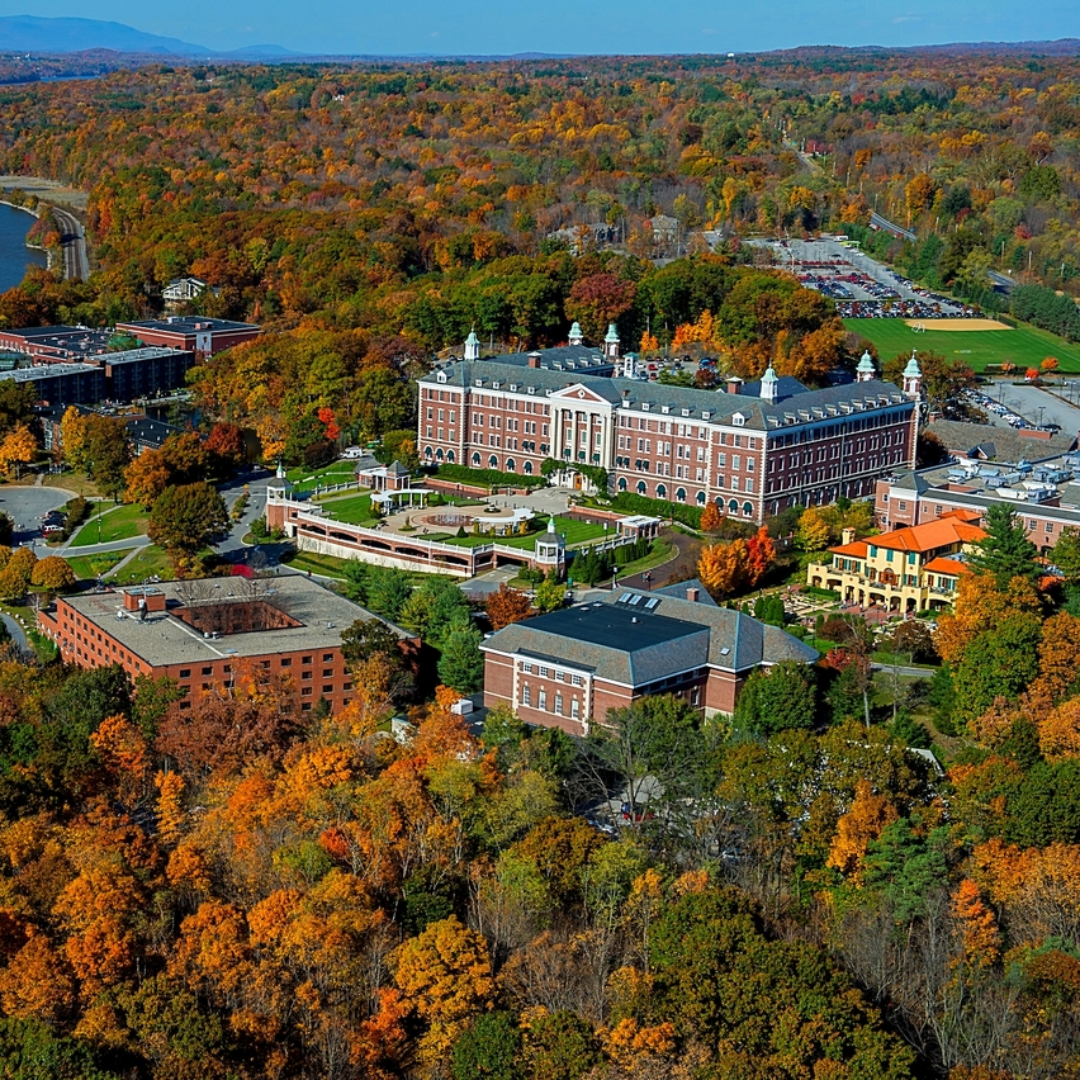 Aerial view of a campus with classic architecture surrounded by autumn foliage.